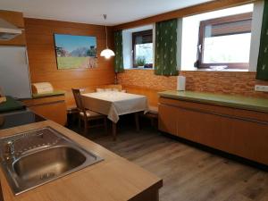 una cocina con fregadero y mesa. en Berghof Knabl en Arzl im Pitztal
