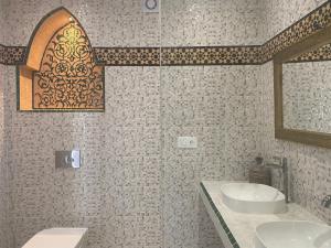 a bathroom with two sinks and a mirror at Dar Narjis in Asilah