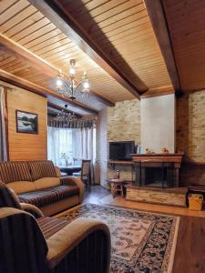 sala de estar con sofá y chimenea en Elf-cottage, en Turʼya Paseka
