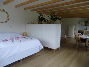 a bedroom with a white bed and a table at de Tulp in Noordgouwe