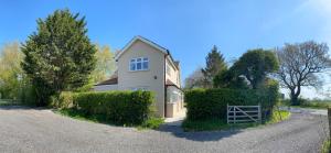 a white house with a gate in front of a driveway at Spacious 4 bed family cottage in parkland setting in York