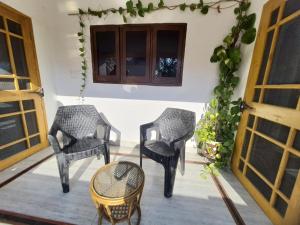 two chairs and a table on a porch at Nature View Homestay in Dehradun