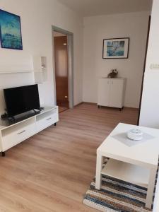 a living room with a television and a white table at Apartment JANDA - Zadar Croatia in Zadar