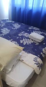 a bed with a blue blanket and pillows on it at Eagle's Nest - Furnished 1BR Condo w/ WIFI in Manila