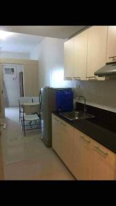 cocina con fregadero y nevera en Eagle's Nest - Furnished 1BR Condo w/ WIFI en Manila