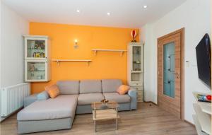 a living room with a couch and an orange wall at 2 Bedroom Nice Apartment In Kornic in Kornić