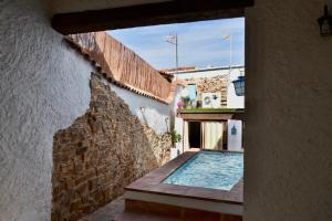 a house with a swimming pool next to a wall at Casa rural El Nido de Despeñaperros in Santa Elena