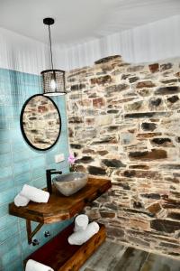 a stone bathroom with a sink and a stone wall at Casa rural El Nido de Despeñaperros in Santa Elena