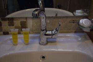 Dois copos de cerveja sentados no lavatório da casa de banho. em Baron Palace hotel suites em Aqaba