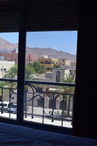 een slaapkamerraam met uitzicht op de stad bij Baron Palace hotel suites in Aqaba