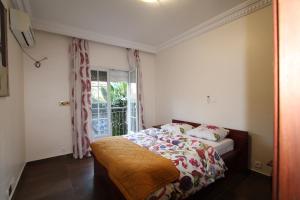 sypialnia z łóżkiem i oknem w obiekcie Residence MASSOU w mieście Jaunde
