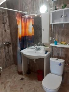 a bathroom with a toilet and a sink and a shower at Апартамент Вангелов in Nesebar