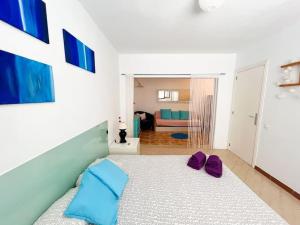 Un dormitorio con una cama con almohadas moradas. en Ca Na Fulla. Agradable casa con jardín y piscina., en Colonia de San Pedro