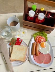 Chalianglom Resort Kohlarn في كو لان: طاولة مع طبق من طعام الإفطار وكوب من القهوة