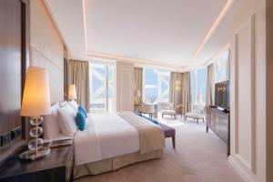 ドーハにあるShaza Dohaのベッドと大きな窓が備わるホテルルームです。