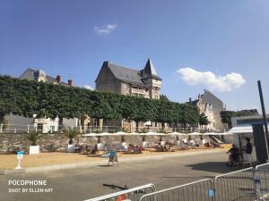 Un groupe de personnes assises sous des parasols près d'un bâtiment dans l'établissement Grand Appartement Confort, à Vichy