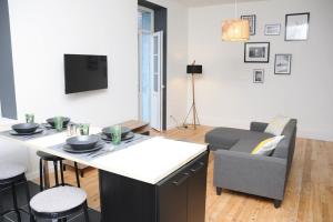 ein Wohnzimmer mit einem Tisch und einem Sofa in der Unterkunft Grand Appartement Confort in Vichy