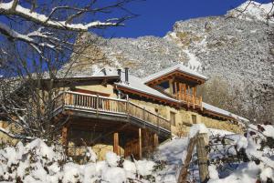 uma cabana de madeira nas montanhas com neve no chão em La Ferme de Beauté em Chateauroux-les-Alpes