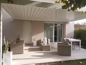 a patio with wicker chairs and a table at Villa moderna a Forte dei Marmi in Forte dei Marmi