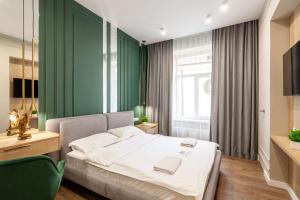 リヴィウにあるLEOGRAND VIP Apartments on Lesi Ukrainky 7の緑の壁、ベッド付きのベッドルーム1室