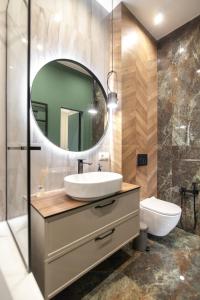 ein Bad mit einem Waschbecken und einem Spiegel in der Unterkunft LEOGRAND VIP Apartments on Lesi Ukrainky 7 in Lwiw