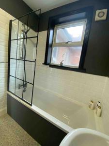 uma casa de banho com um WC, uma janela e um lavatório. em 1 bed flat with parking near town centre em Emsworth