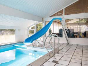 - une piscine avec toboggan bleu dans une maison dans l'établissement 12 person holiday home in Saltum, à Saltum