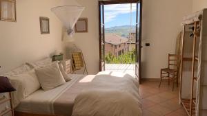 a bedroom with a bed and a balcony with a view at Viaggio della Vita B&B in Fontanile