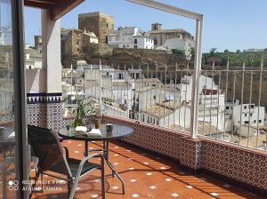 a balcony with a table and a view of a city at Casa de las Lanzas in Setenil