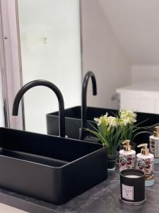 a black sink in a bathroom with flowers and candles at Berg Messe DG 1Zi, K,D,B Parkplatz, W-Lan, Homeoffice in Bergisch Gladbach