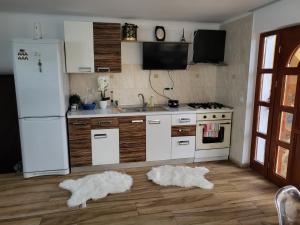 a kitchen with white appliances and white towels on the floor at Vila Sabina ,cu jacuzzi și grătar in terasa exterioara in Satu Mare