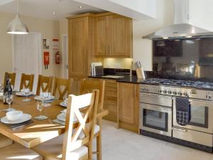 a kitchen with a dining table and a stove at Wyedale in Bakewell