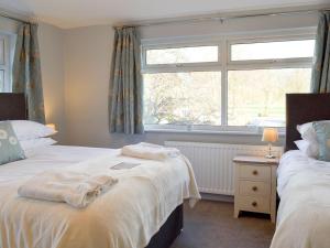 a bedroom with two beds and a window at Wyedale in Bakewell