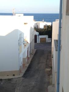 an alley with white buildings and the ocean in the background at La Rosada 9 in Las Negras