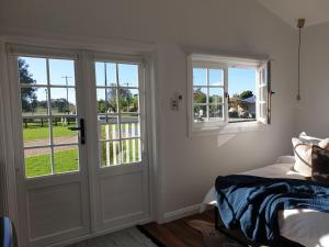 马奇Dangerfield Oaks Boutique Cottage's的卧室设有门窗和床