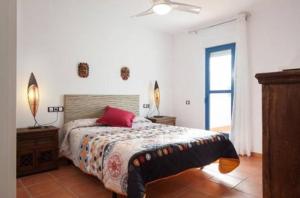 Un dormitorio con una cama con una almohada roja. en La Rosada 9 en Las Negras