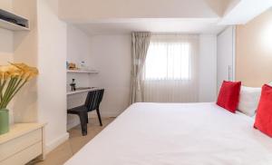 a bedroom with a large white bed with red pillows at Paamonim Central Studios in Jerusalem