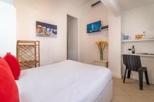 a bedroom with a white bed and a chair at Paamonim Central Studios in Jerusalem