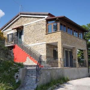 a brick house with stairs in front of it at Casa vacanze Lago di Campotosto in Campotosto