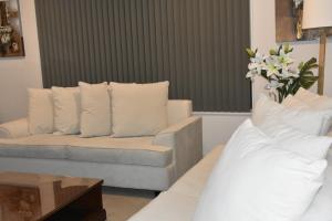 a living room with a couch and white pillows at The Rise BNB - Executive Ensuite in Auckland