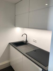 a kitchen with a sink and white cabinets at Apartment Lake`s in Pörtschach am Wörthersee