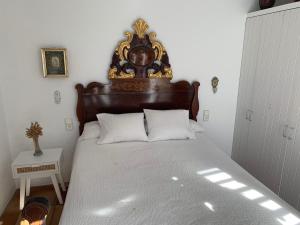 Schlafzimmer mit einem großen Bett mit einem Kopfteil aus Holz in der Unterkunft Es Forn - Cadaqués in Cadaqués