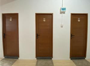 drei Holztüren an einer weißen Wand in der Unterkunft CN Homestay C1 Floor 3 at Nagoya Hill Mall in Nagoya