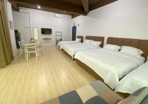 a hotel room with two beds and a table and a television at CN Homestay C2 Floor 3 at Nagoya Hill Mall in Nagoya