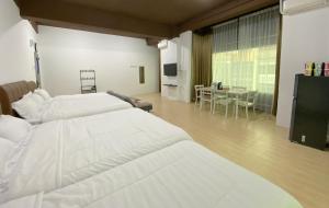 a hotel room with two beds and a dining room at CN Homestay C3 Floor 3 at Nagoya Hill Mall in Nagoya