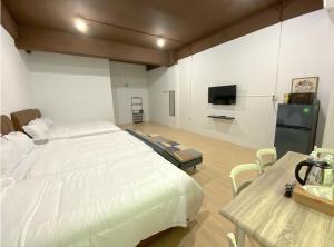 ein Schlafzimmer mit einem großen weißen Bett und einem TV in der Unterkunft CN Homestay C1 Floor 3 at Nagoya Hill Mall in Nagoya