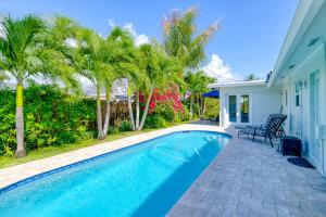 a swimming pool in the backyard of a house with palm trees at Pompano Treasure in Pompano Beach
