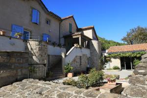 a stone house with a gate and a building at Le clair de lune in Millau