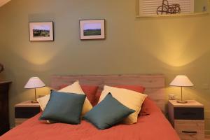 a bedroom with a red bed with three pillows at Le clair de lune in Millau