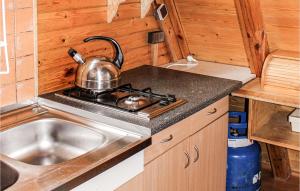 La cocina está equipada con fregadero y fogones con hervidor de agua. en Holiday Home Lukecin Ulsloneczna, en Łukęcin
